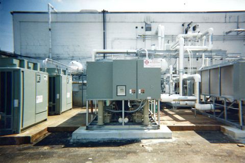 Packaged air conditioning units and plant piping on a commercial rooftop pad